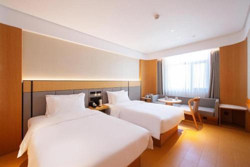 سرير أو أسرّة في غرفة في Ji Hotel Changchun Beihu