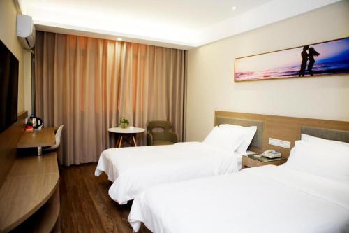 سرير أو أسرّة في غرفة في Hanting Hotel Cangzhou Haixing