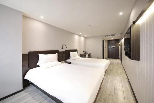 A bed or beds in a room at Hi Inn Suzhou Shilu Shantang Street