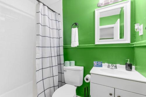 a green bathroom with a toilet and a sink at The Bricks - Apt 4 in Birmingham