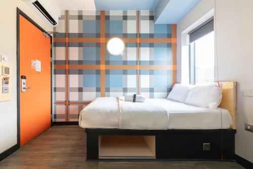 a bedroom with a bed and a striped wall at easyHotel Glasgow City in Glasgow
