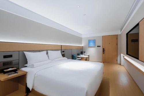 Een bed of bedden in een kamer bij Ji Hotel Fuzhou Wuyi Square