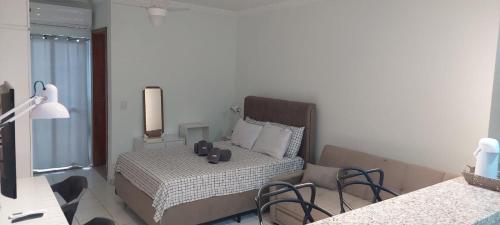 a bedroom with a bed and a table and chairs at Edifício Belluno in Ribeirão Preto