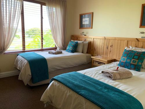 a hotel room with two beds and a window at Keurbooms River Lodge 1115 in Plettenberg Bay