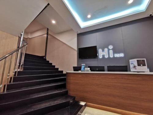 a staircase leading up to a lobby with a cash register at Hi Inn Beijing Chaoyangmen in Beijing