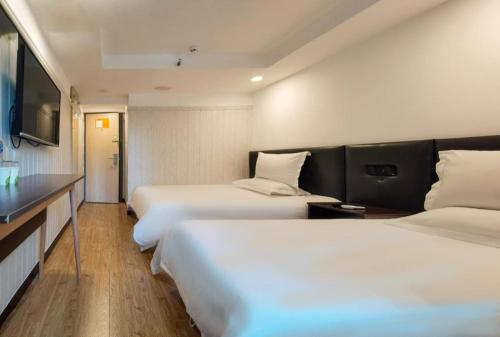a hotel room with two beds and a flat screen tv at Hi Inn Beijing Chaoyangmen in Beijing