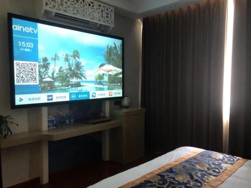 1 dormitorio con TV de pantalla grande en una habitación en Elan Boutique Hotel Wenzhou Longwan Haicheng, en Ch'a-shan-chieh