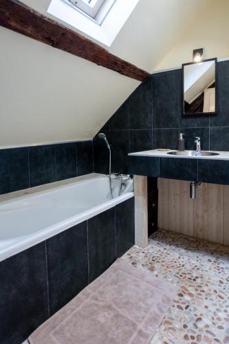 une salle de bain avec une baignoire et un lavabo dans l'établissement Le duplex de Lise, à Honfleur