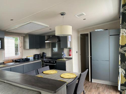 a kitchen with a dining table and a refrigerator at Blackpool caravans dog friendly in Blackpool