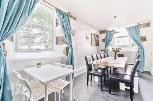 a dining room with blue curtains and a table and chairs at The Old Chapel in Camborne