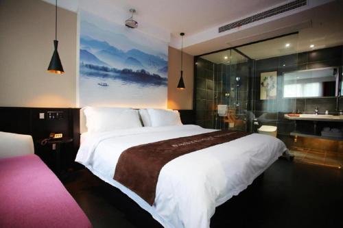 a bedroom with a large bed and a bathroom at Hanting Hotel Chuzhou Dingyuan Shopping Building in Dingyuan
