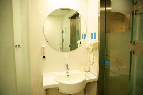 a bathroom with a sink and a mirror at Hanting Hotel Changzhi Town God Temple in Changzhi