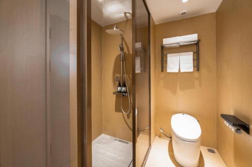 a bathroom with a shower with a toilet and a glass door at Ji Hotel Nanping Jianyang District Government in Tancheng