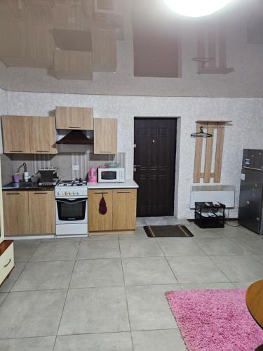 a kitchen with wooden cabinets and a stove top oven at Апартаменти в Кропивницькому in Kropyvnytskyi