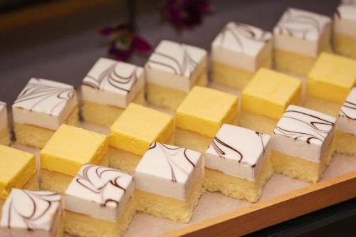 un groupe de gâteaux jaunes et blancs sur un plateau de découpe dans l'établissement Ji Hotel Hangzhou Westlake Culture Plaza, à Hangzhou