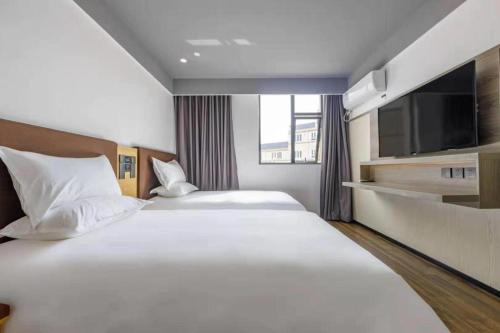 上海的住宿－Hi Inn Shanghai International Exhibition Center Jidi Road，酒店客房设有两张床和一台平面电视。