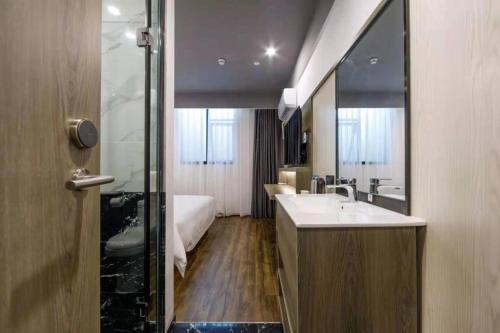 uma casa de banho com uma banheira, um lavatório e um espelho. em Hi Inn Shanghai International Exhibition Center Jidi Road em Xangai