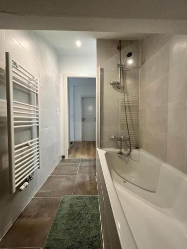 une grande salle de bain avec baignoire et douche dans l'établissement Spacieux appartement neuf au cœur de Bisca plage, à Biscarrosse