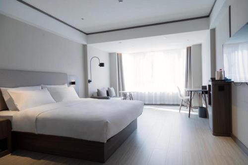 Łóżko lub łóżka w pokoju w obiekcie Hanting Hotel Jiamusi Huanan Xinjian Street