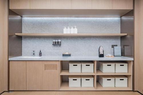 a kitchen with a counter with a sink and shelves at Ji Hotel Zibo Jinjing Avenue in Zibo
