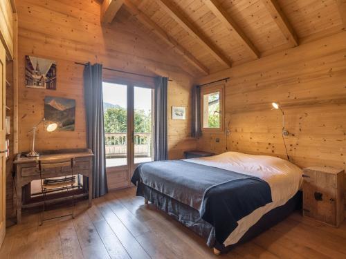 a bedroom in a log cabin with a bed and a window at Chalet 4*, 5 chambres, hammam, cheminée, garage, WIFI, 10 personnes - FR-1-304-140 in La Clusaz