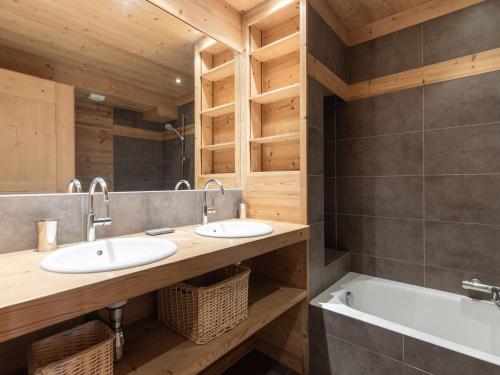 une salle de bain avec deux lavabos et une baignoire dans l'établissement Chalet 4*, 5 chambres, hammam, cheminée, garage, WIFI, 10 personnes - FR-1-304-140, à La Clusaz