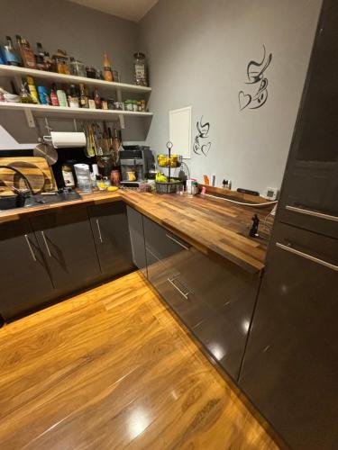 a kitchen with a wooden counter top and wooden floors at 2 Bed Home in Luton