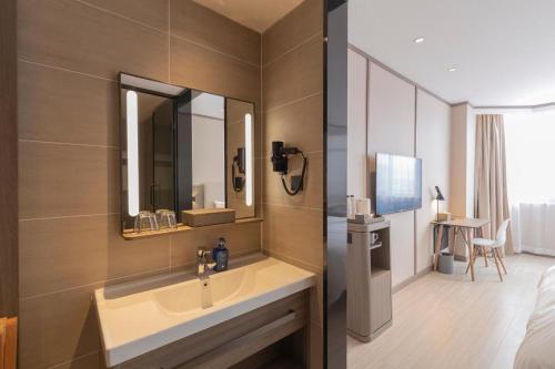 a bathroom with a sink and a mirror at Hanting Hotel Lingbao Municipal Government in Ling-pao-hsien