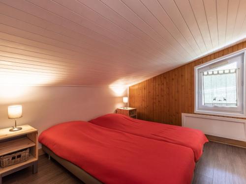 - une chambre avec un lit rouge et une fenêtre dans l'établissement Beau T2+mezz+coinnuit, 6-7 pers, garage - FR-1-304-175, à La Clusaz