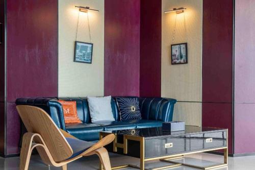 uma sala de estar com um sofá azul e uma mesa em Hanting Hotel Xiamen Huli Avenue Free Trade Zone em Huli