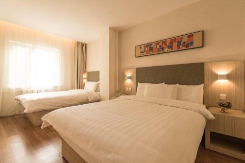Łóżko lub łóżka w pokoju w obiekcie Hanting Hotel Xining Huangguang Mojia Street