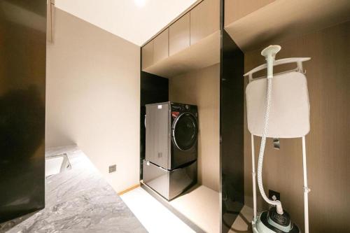 a room with a washing machine and a lamp at Ji Hotel Beijing Sanlitun Soho in Beijing