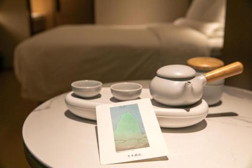 a table with bowls and a tea set on it at Ji Hotel Beijing Sanlitun Soho in Beijing