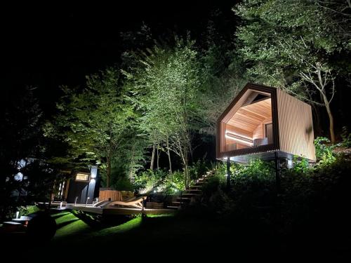 a small wooden house in the woods at night at Fenyővölgy Luxus Pihenőház ***** Mátrakeresztes in Matrakeresztes