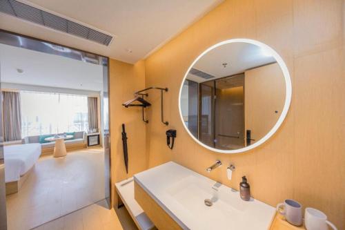 a bathroom with a sink and a mirror at Ji Hotel Xuzhou Administrative Center Metro Station in Liuji