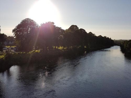 a river with the sun reflecting on the water at Bronwye in Builth Wells