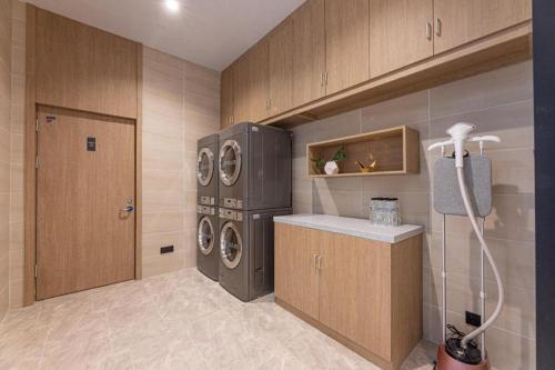 a laundry room with a washer and dryer at Hanting Hotel Yangzhou Jiangdu Wenchang East Road in Jiangdu