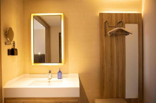 bagno con lavandino e doccia con specchio di Hanting Hotel Ordos Yijinholoqi Wenming Road a Ordos
