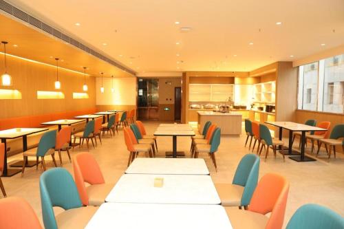 un ristorante con tavoli e sedie e una cucina di Hanting Hotel Ordos Yijinholoqi Wenming Road a Ordos