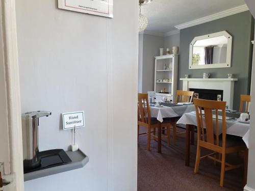 a dining room with a table and chairs and a mirror at Bronwye in Builth Wells