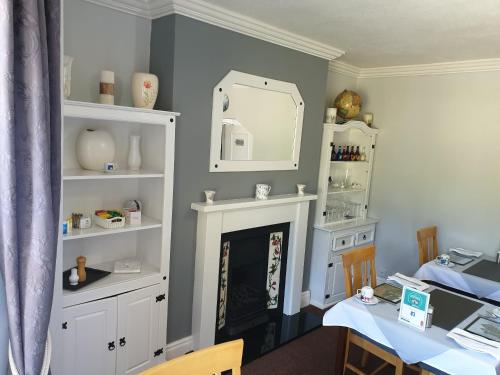 a living room with a table and a fireplace at Bronwye in Builth Wells