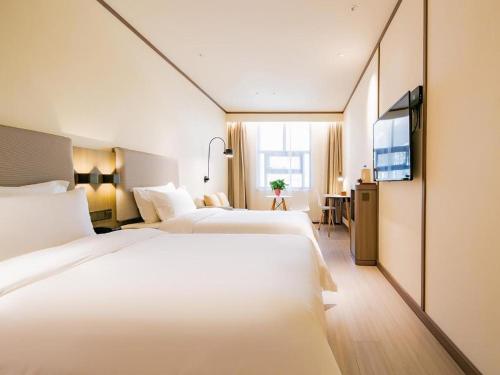 سرير أو أسرّة في غرفة في Hanting Hotel Yan'An Railway Station