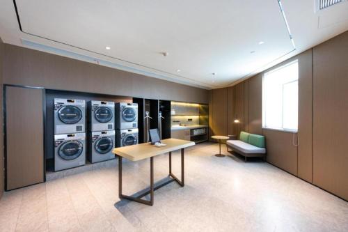 a room with three washing machines and a table at Ji Hotel Taizhou Pedestrian Street in Taizhou