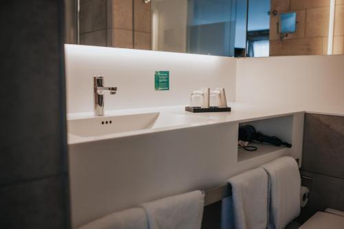 a bathroom with a sink and a mirror at Design Hotel & Restaurant Löwen in Ulm