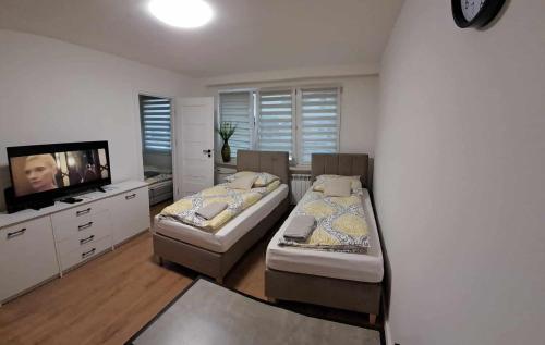 a bedroom with two beds and a flat screen tv at Apartament Julia 1-4 os parter Centrum in Kielce