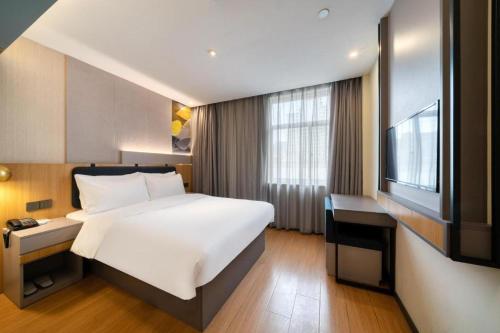 Un pat sau paturi într-o cameră la Hanting Hotel Hangzhou Zhejiang University City College