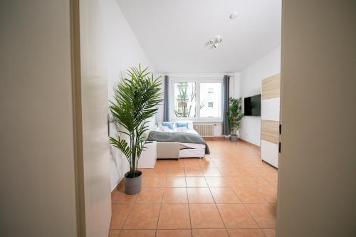 een slaapkamer met een bed en een potplant bij Apartment - Central with Balcony - Kitchen & More in Düsseldorf