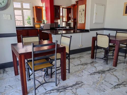 a kitchen with two tables and chairs and a counter at Luxe Florida Grand Hotel in Durban