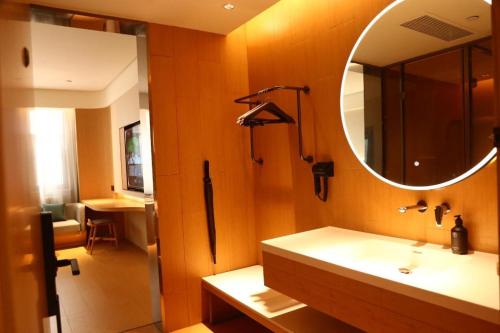 een badkamer met een wastafel en een spiegel bij Ji Hotel Bayanzhuo'Er Books Tower in Bayan Nur