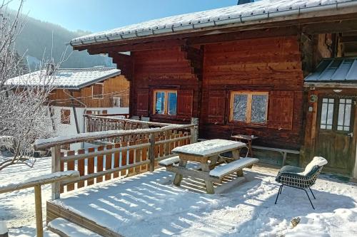 a wooden cabin in the snow with a table and a bench at Savoyard nest with Mont Blanc view in Flumet